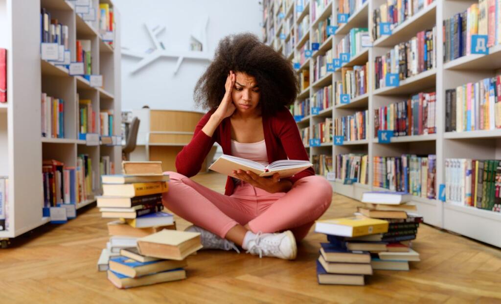 A student in stress sitting on floor in library